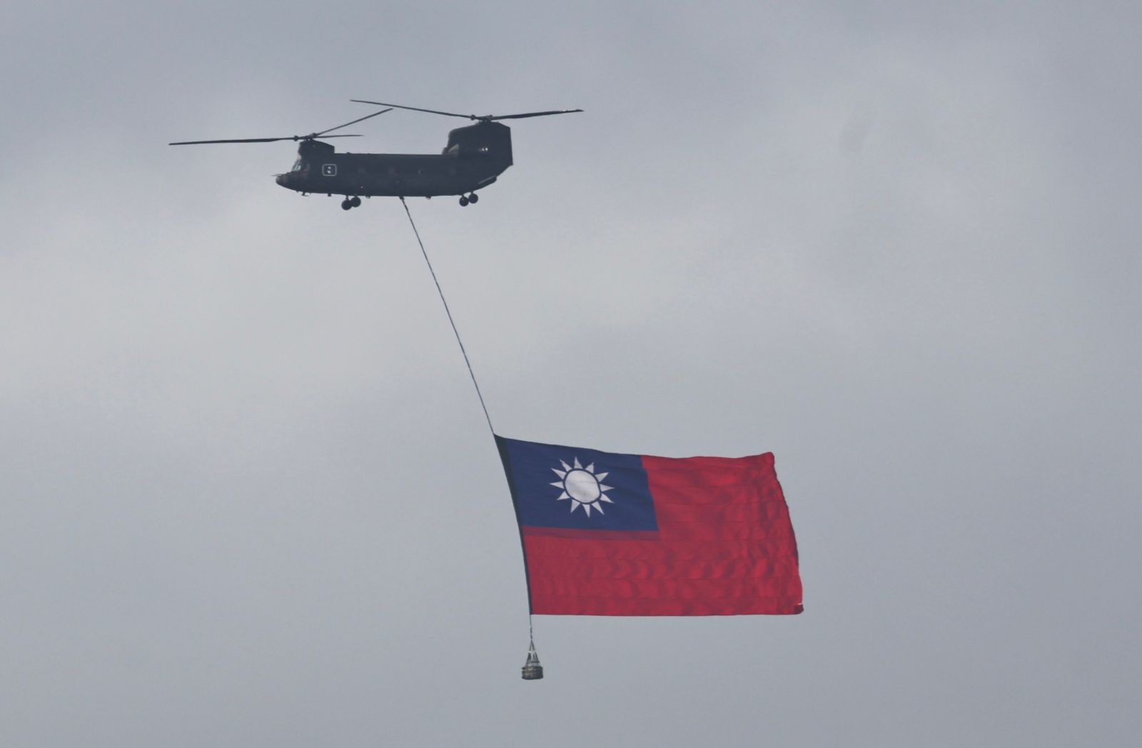 CH-47SD運輸直升機吊掛國旗通過總統府前廣場。林啟弘攝
