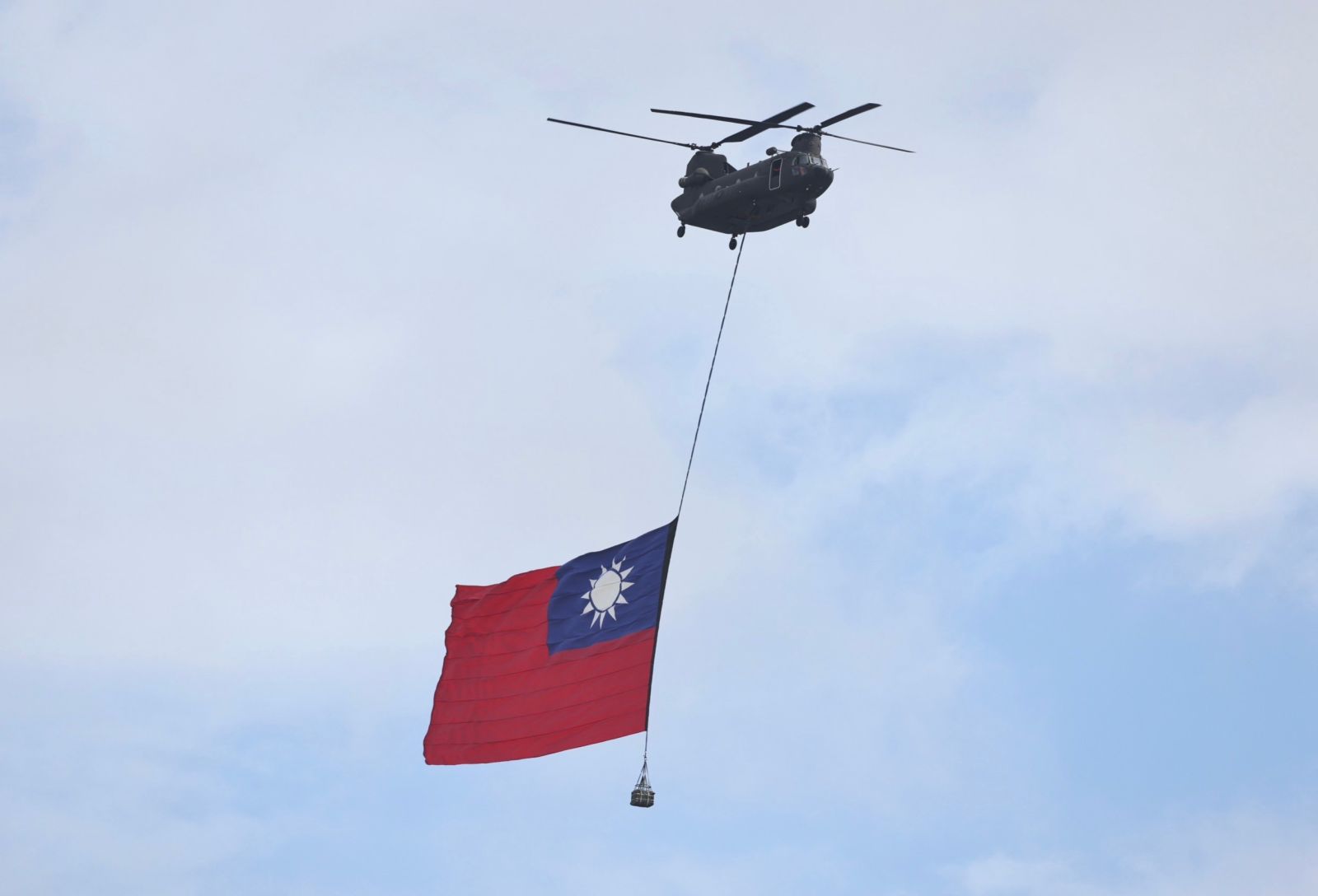 巨幅國旗在2架UH-60M黑鷹直升機護衛下，通過府前廣場。林啟弘攝