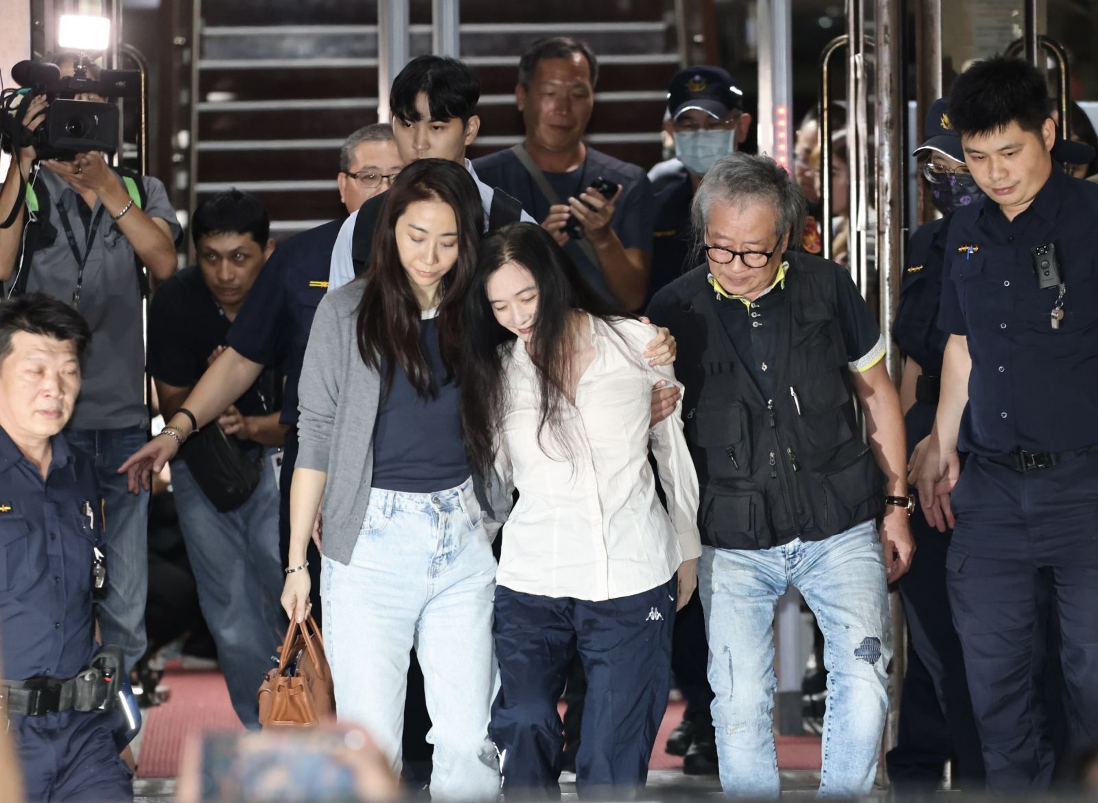 應曉薇晚間在律師及胞兄攙扶下雙手合十步出法院,期間下樓梯時險些跌倒。林啟弘攝