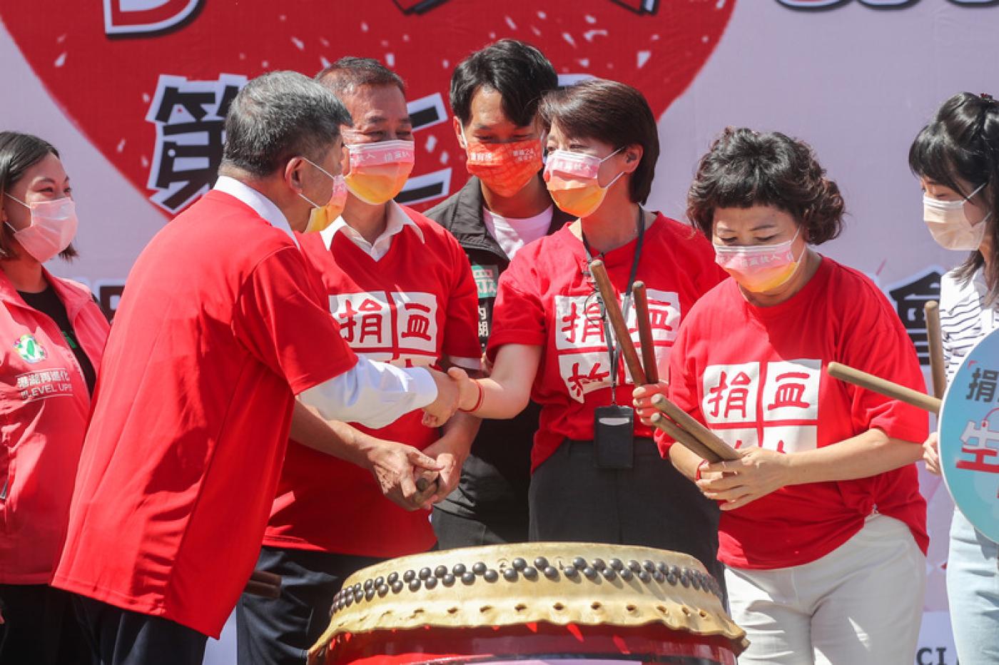 台北市副市長黃珊珊（右3）與民進黨台北市長參選人陳時中（左2）24日同台出席捐血活動，兩人握手致意。中央社