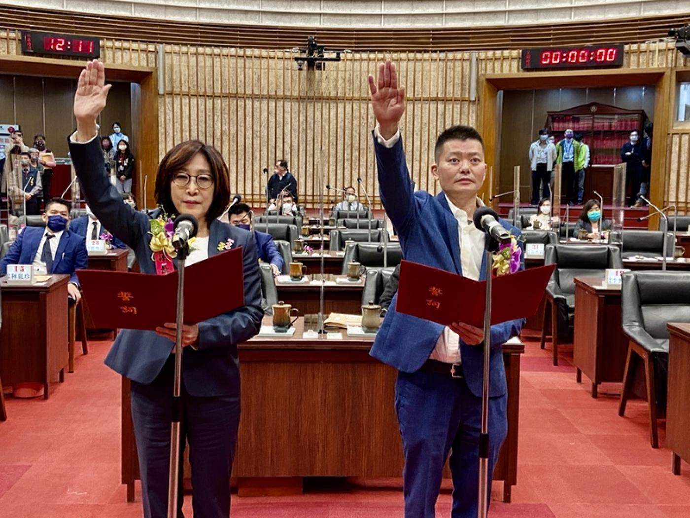 民進黨康裕成（前左）與24日宣布退出國民黨的曾俊傑（前右）搭當選高雄市正副議長，2人宣誓就職。中央社