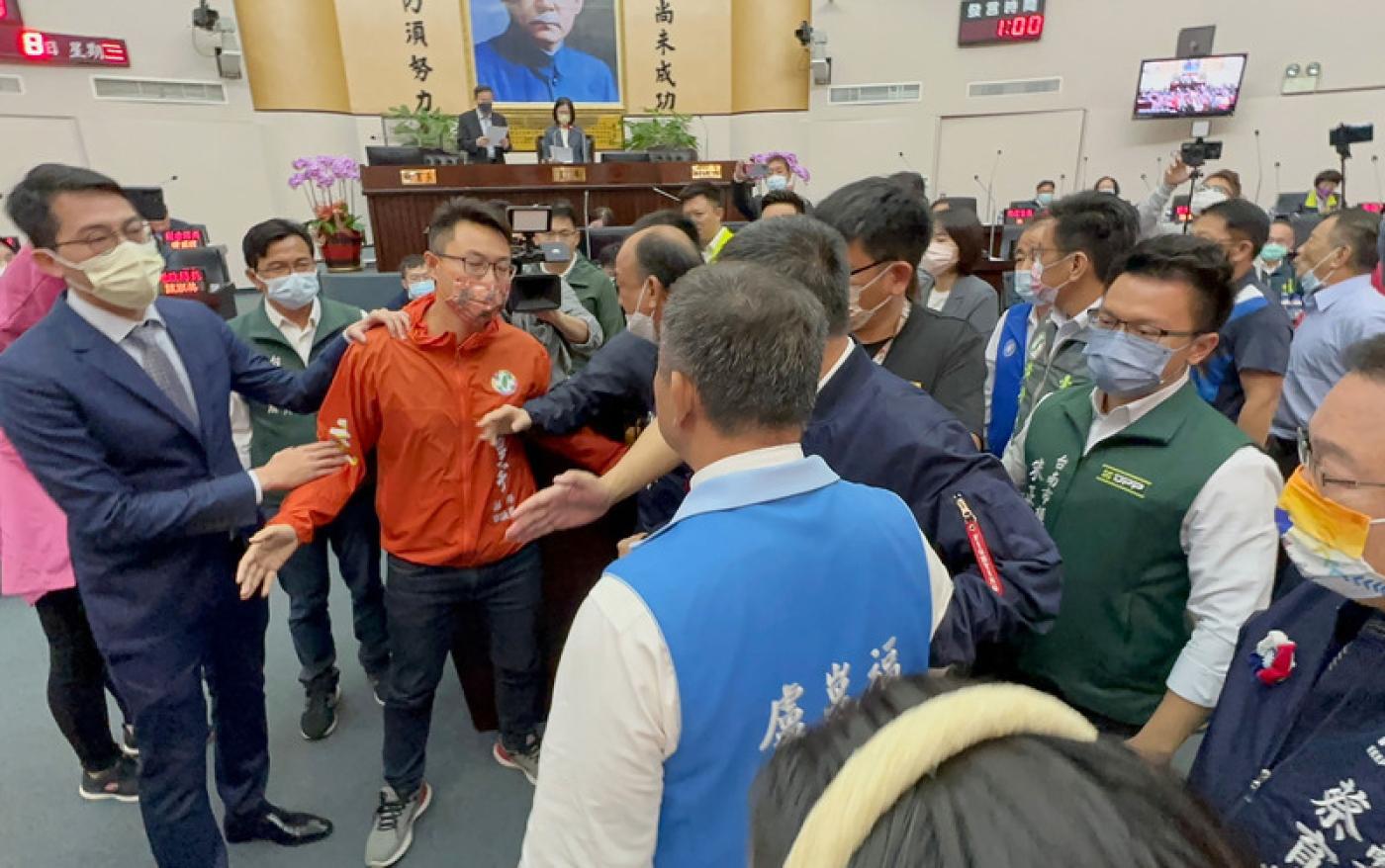 涉入正副議長賄選案的台南市議長邱莉莉8日主持臨時會，國民黨議員盧崑福質疑邱莉莉立場，要求請假 避嫌，且衝上主席台，但中途被眾人攔下，引發推擠拉址。中央社