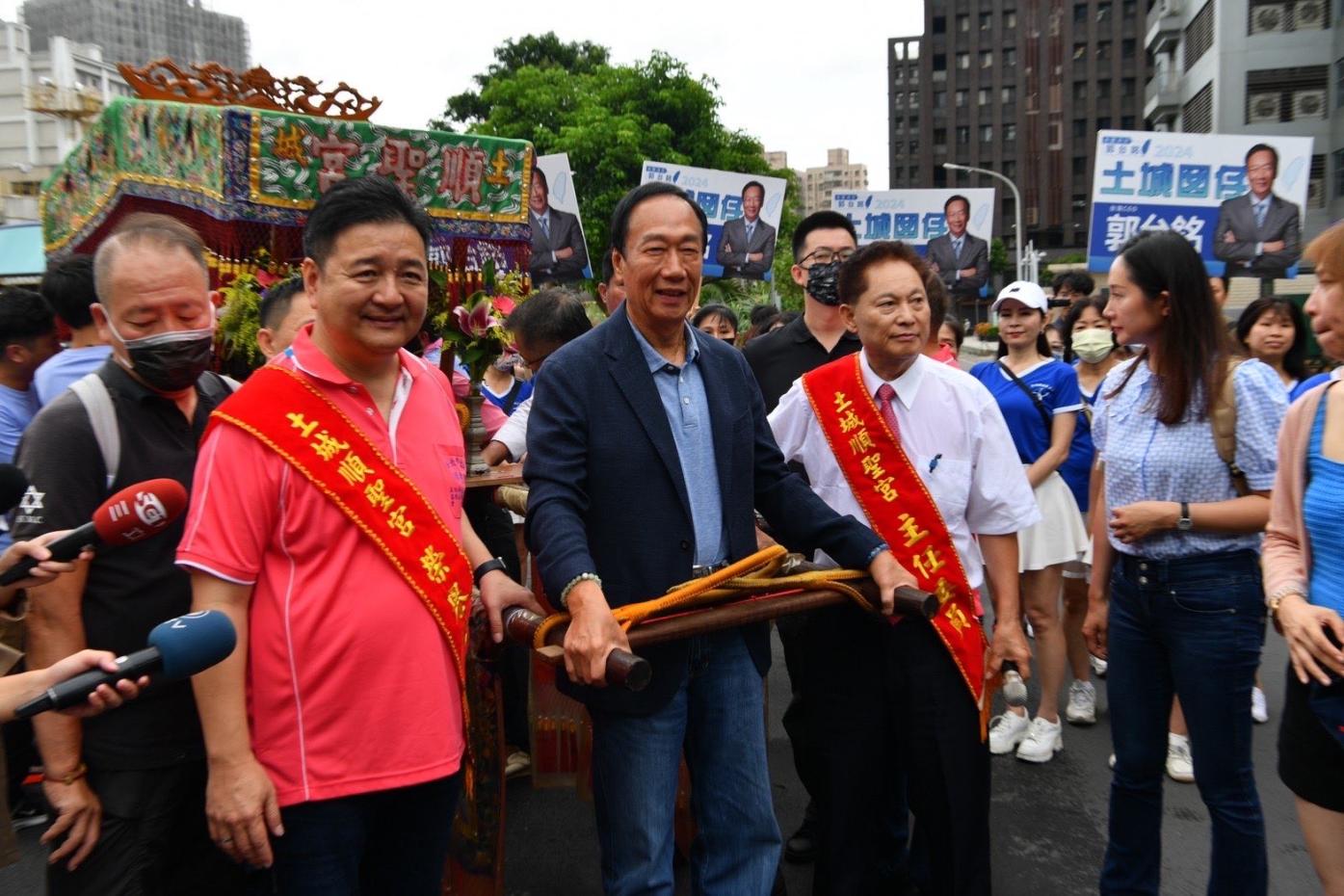 鴻海創辦人郭台銘(中)出席土城宮廟活動，國民黨立委參選人林金結(左)和郭互動密切。郭台銘辦公室提供