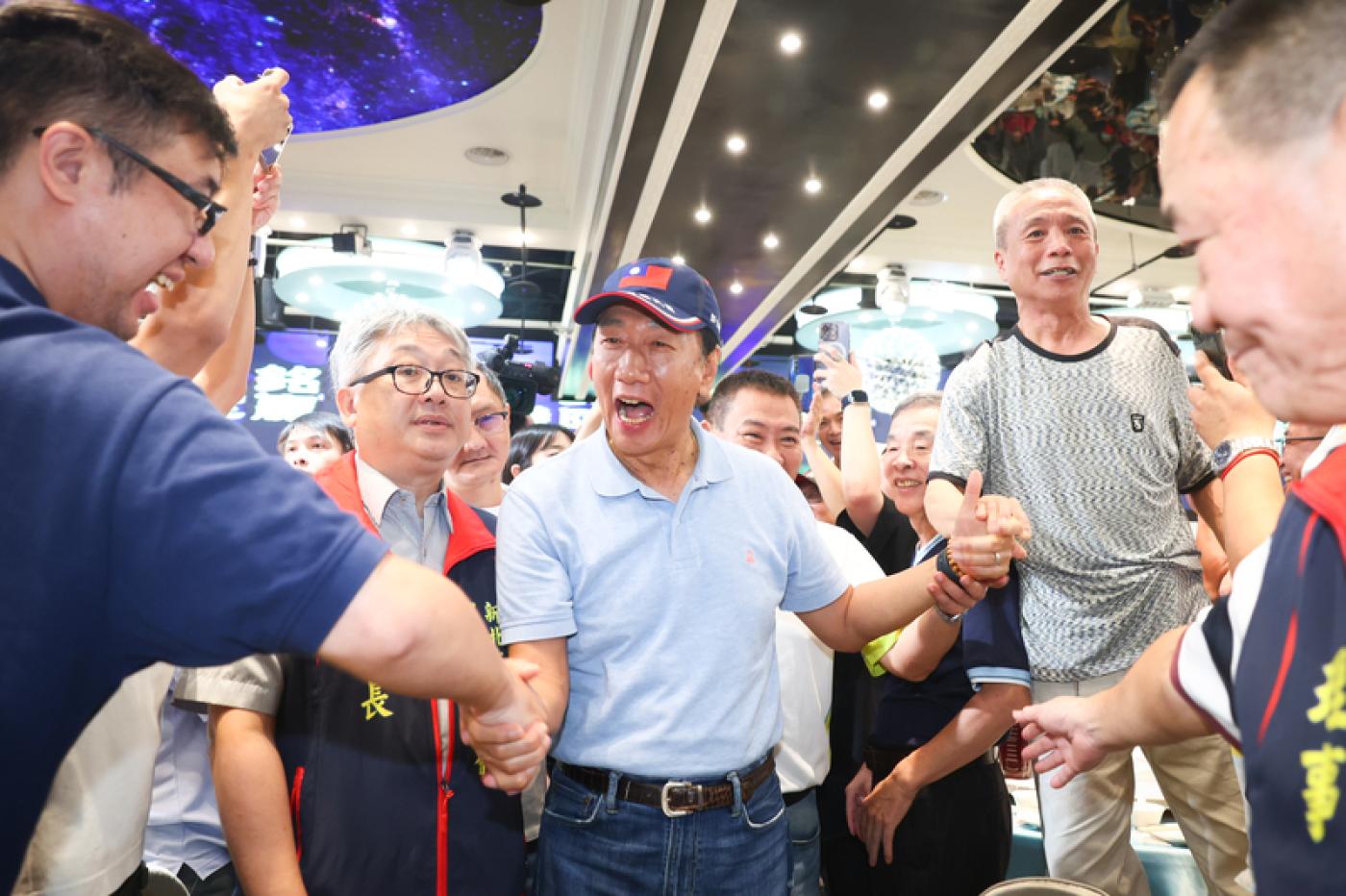 鴻海創辦人郭台銘（中）3日晚間參加新北市計程車工會成立40周年紀念餐會，入場時受到民眾熱烈歡迎。中央社