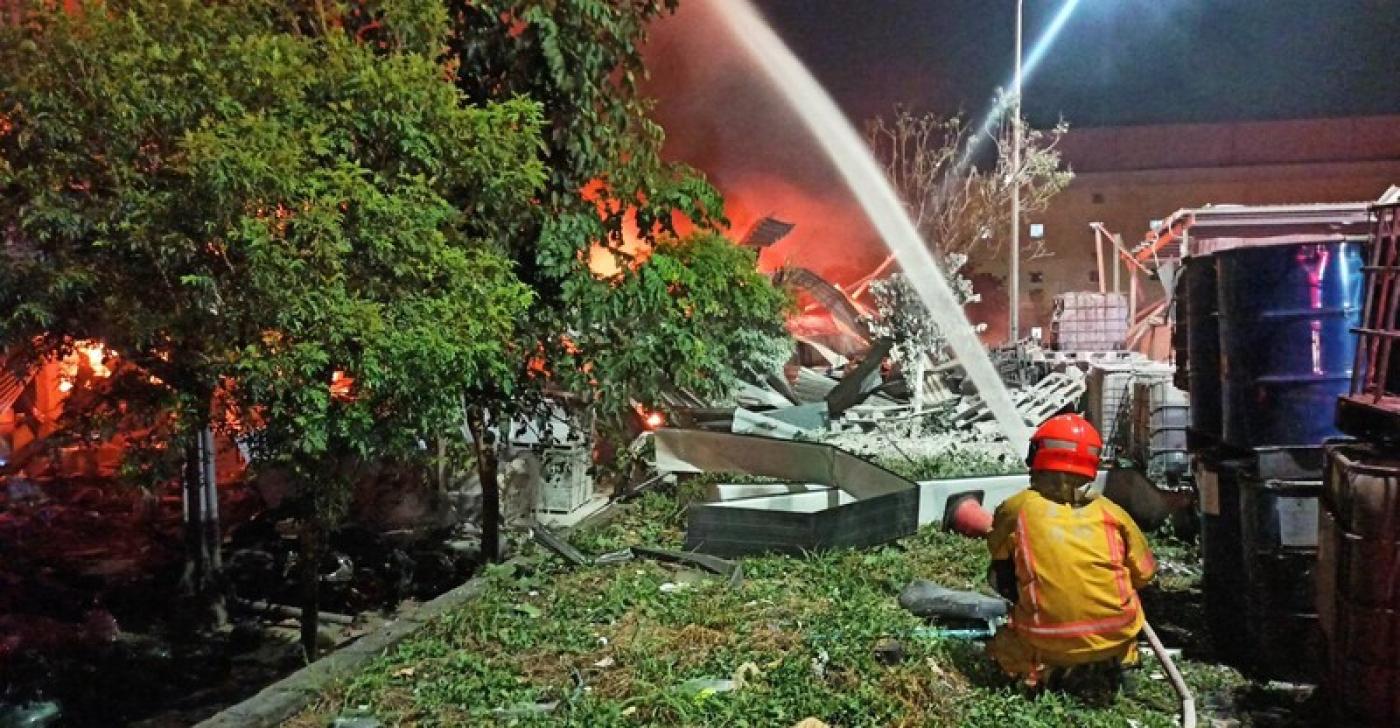 明揚國際公司位於屏東的工廠昨發生火警爆炸意外，現場消防員射水降溫滅火。中央社