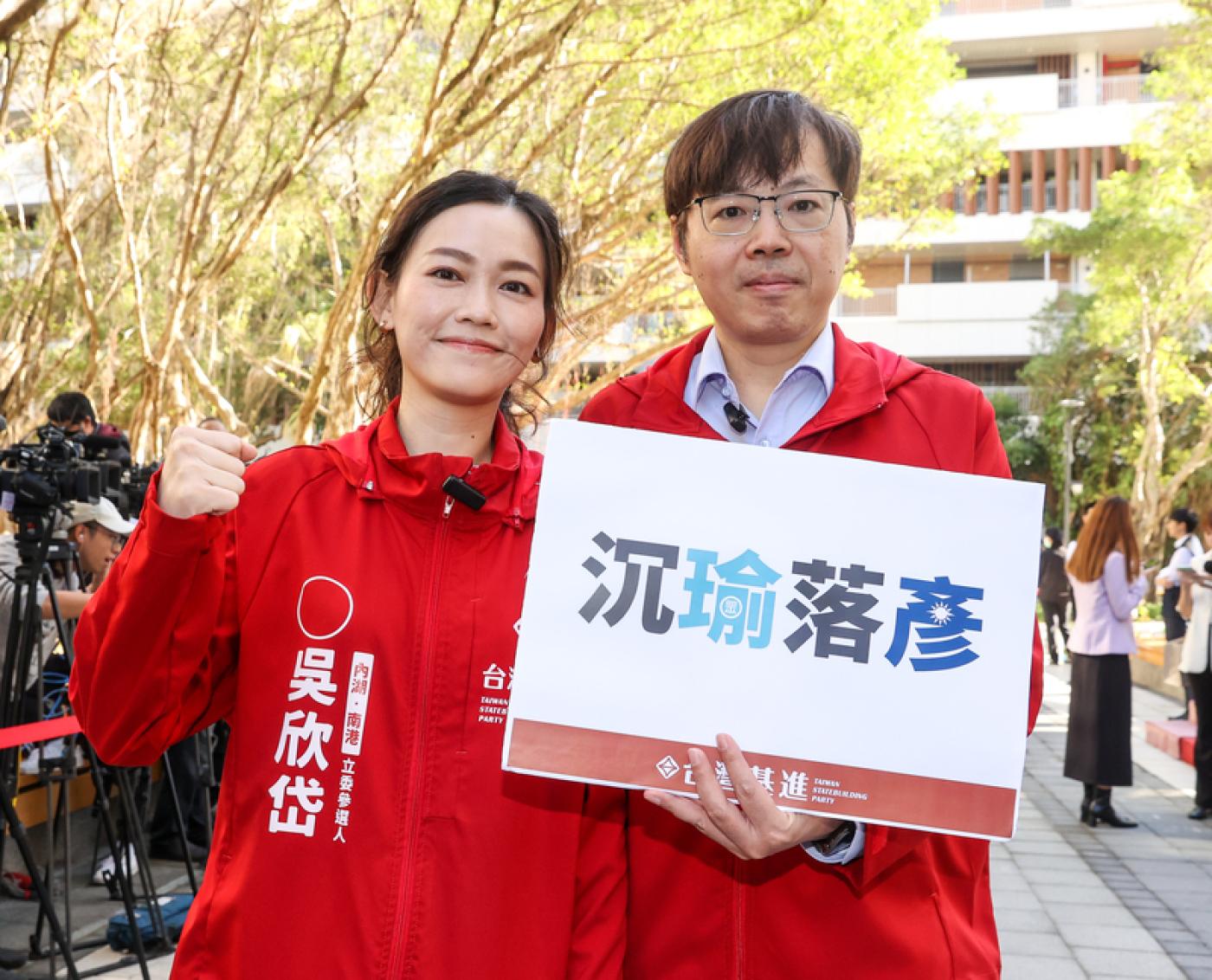 吳欣岱（左）22日在台灣基進黨主席王興煥（右）陪同下前往台北市選舉委員會登記參選。中央社