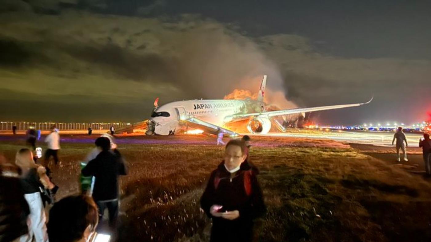 一名外國乘客2日自JL516班機成功逃生，在安全地點回頭拍下班機失火照片。翻攝@wmanzione「X」社群平台