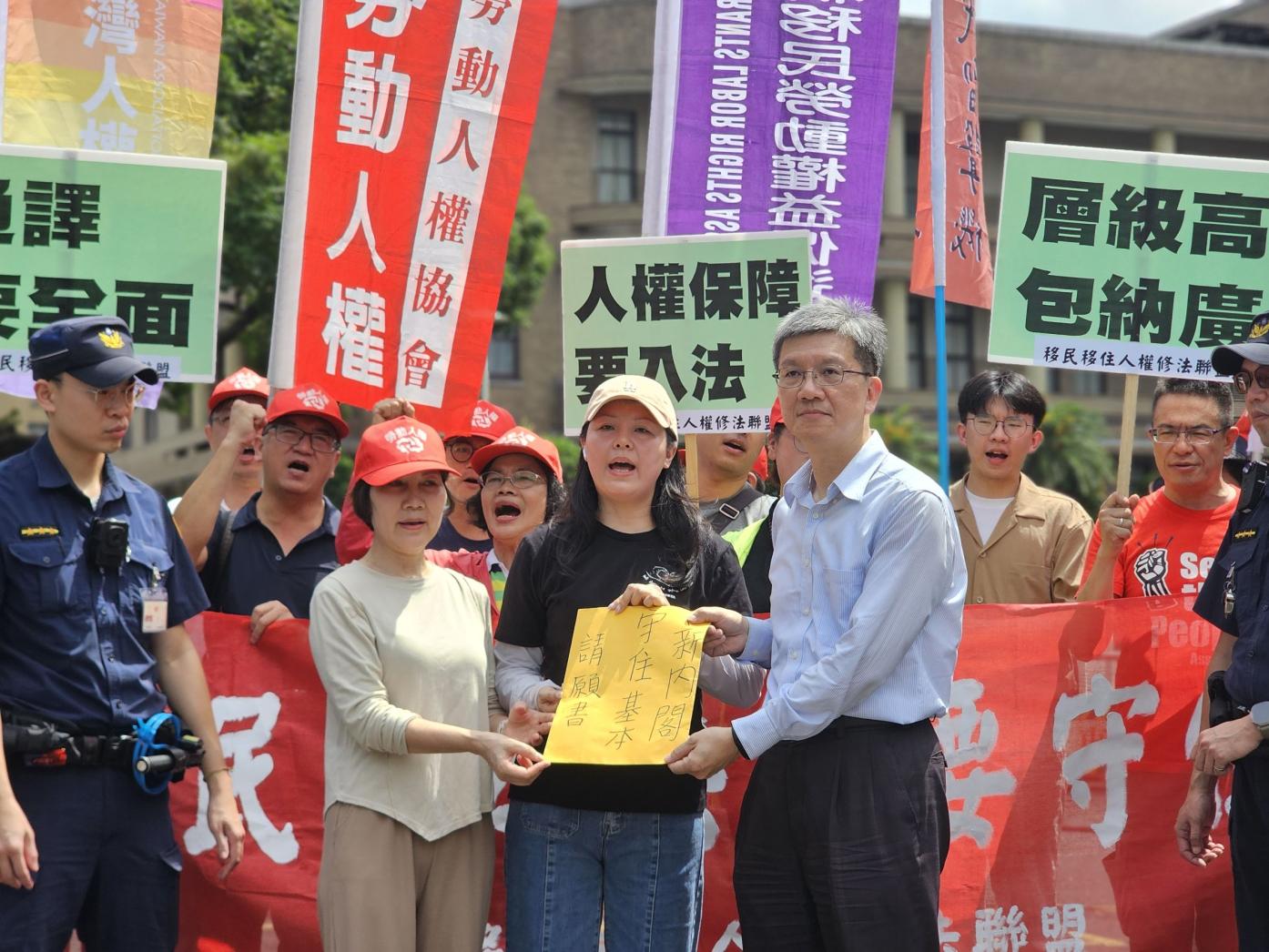 移盟等團體赴行政院請願，由行政院外交國防法務處副處長陳永智出面接下請願書。