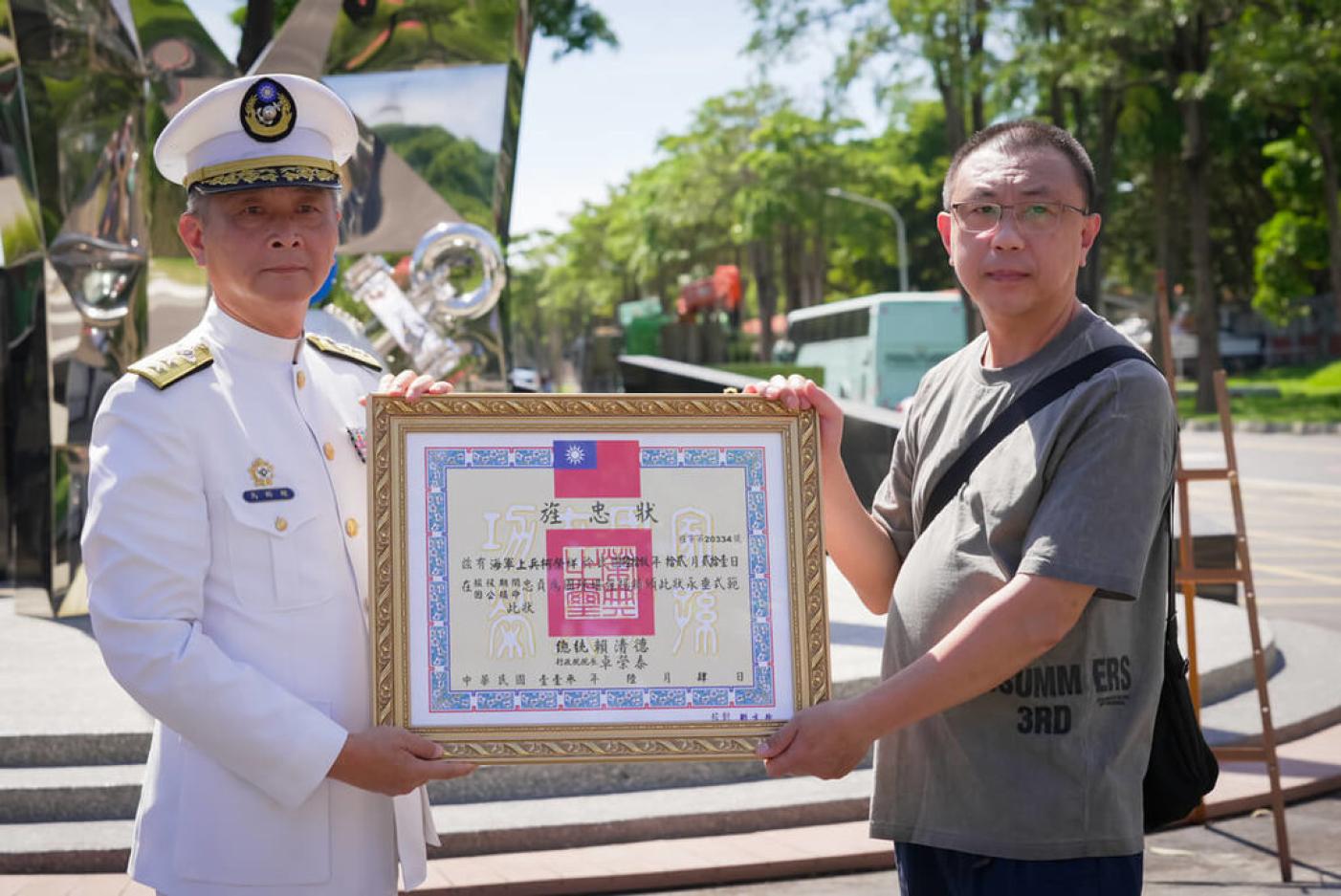 海軍陸戰隊28日舉行「聯興22號演習將士追悼紀念儀式」，指揮官馬群超中將（左）致贈遺眷代表「旌忠狀」。立委林岱樺國會辦公室提供