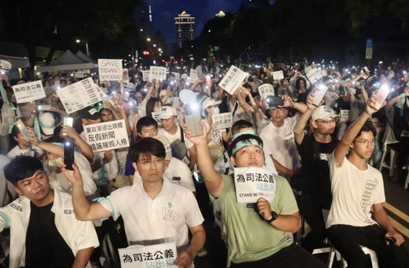 民眾黨主席柯文哲被控於台北市長任內涉嫌圖利京華城案等罪，遭台北地方法院裁定羈押禁見。民眾黨8日晚間在立法院旁發起首場公民開講活動，現場支持者手持各式標語表達訴求。中央社