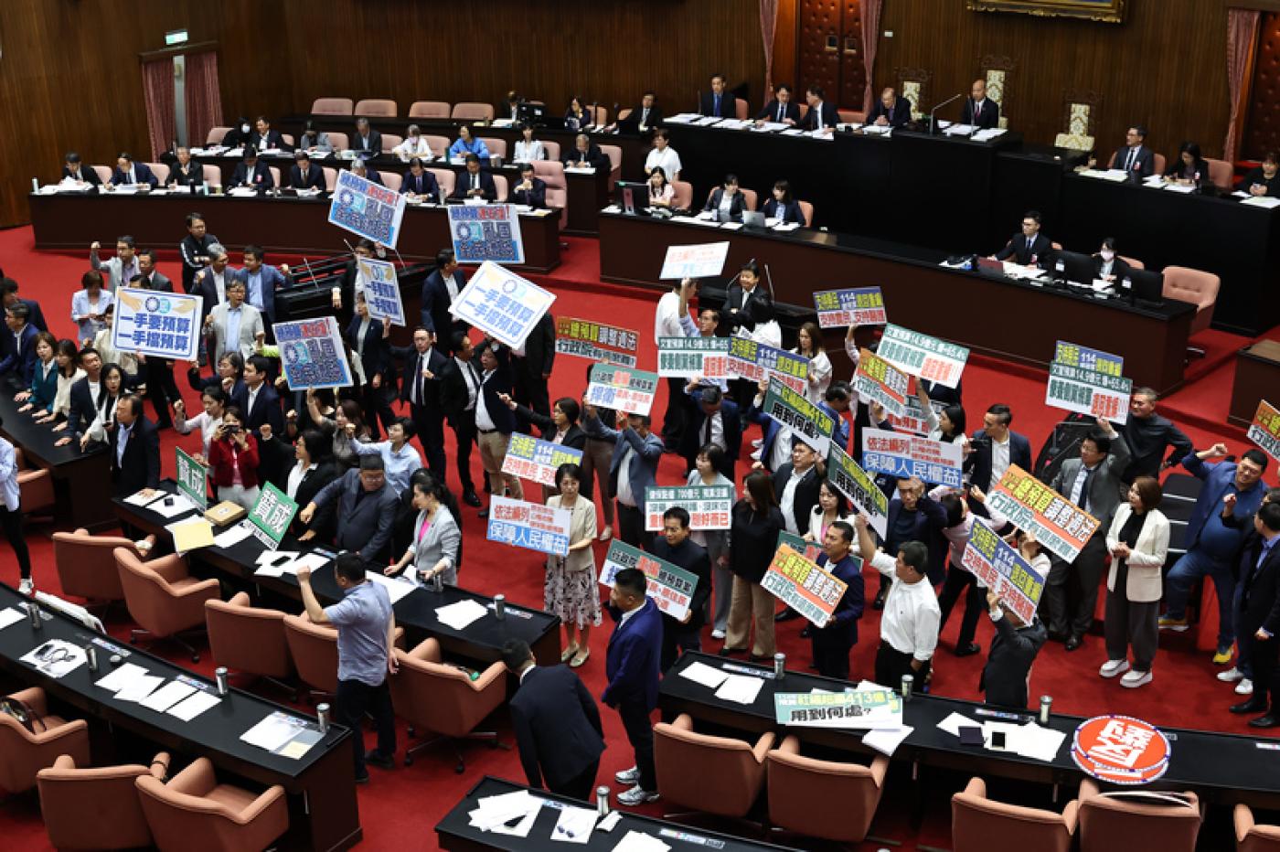 民進黨團、國民黨團在議場內舉看板表示意見。中央社