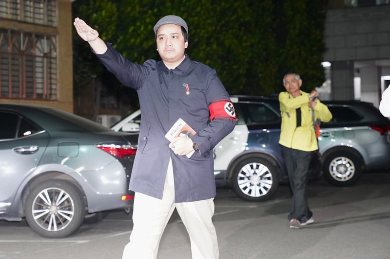 提議罷免民進黨立委李坤城領銜人宋建樑（前）晚間移送新北檢複訊時，戴納粹臂章、比納粹手勢、還拿著希特勒著作《我的奮鬥》。中央社