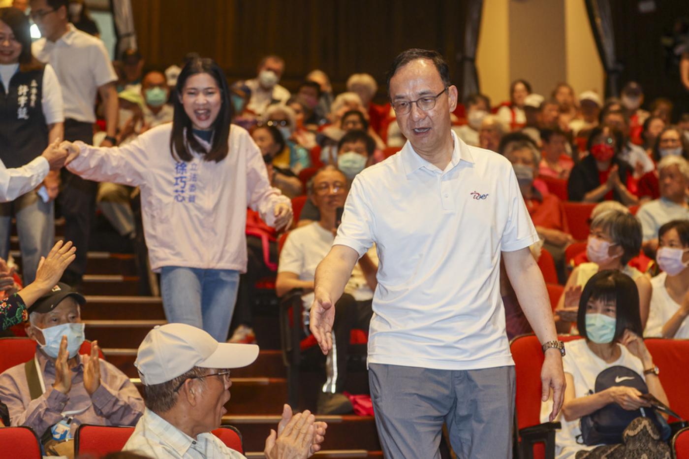 國民黨主席朱立倫（前右）20日下午在台北出席「戰獨裁 站出來」政策說明會，與黨籍立委徐巧芯（後左）一同入場並和支持者握手致意。中央社