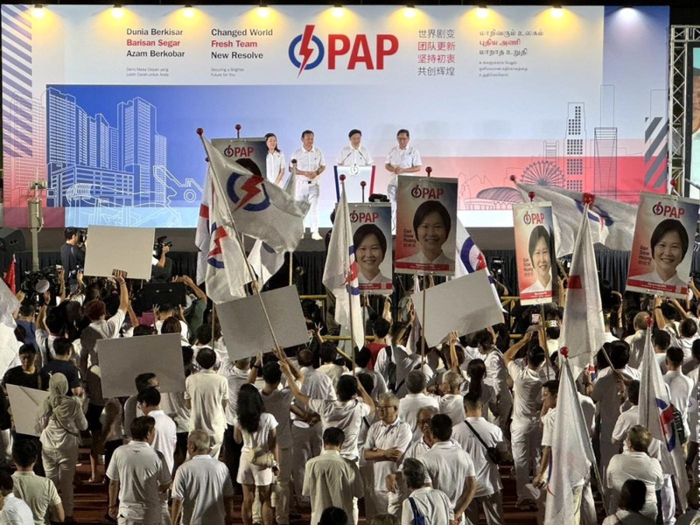 新加坡大選結果4日凌晨出爐，人民行動黨蟬連執政，黨秘書長黃循財（台上右2）上台致詞時，獲得台下高聲歡呼。 中央社