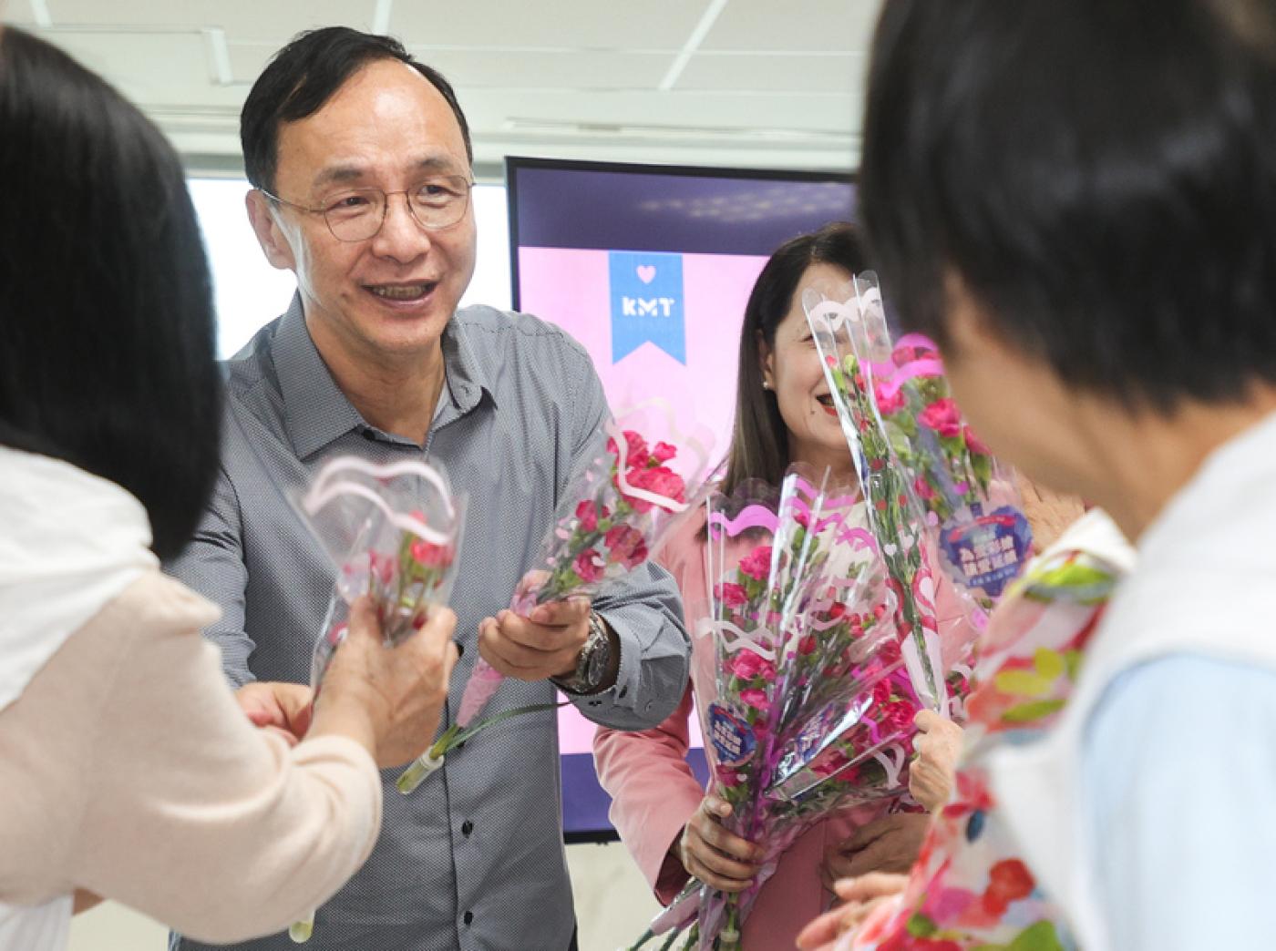 國民黨主席朱立倫（左）8日在出席「為愛彩繪 讓愛延續」母親節慶祝活動，現場發放康乃馨。中央社