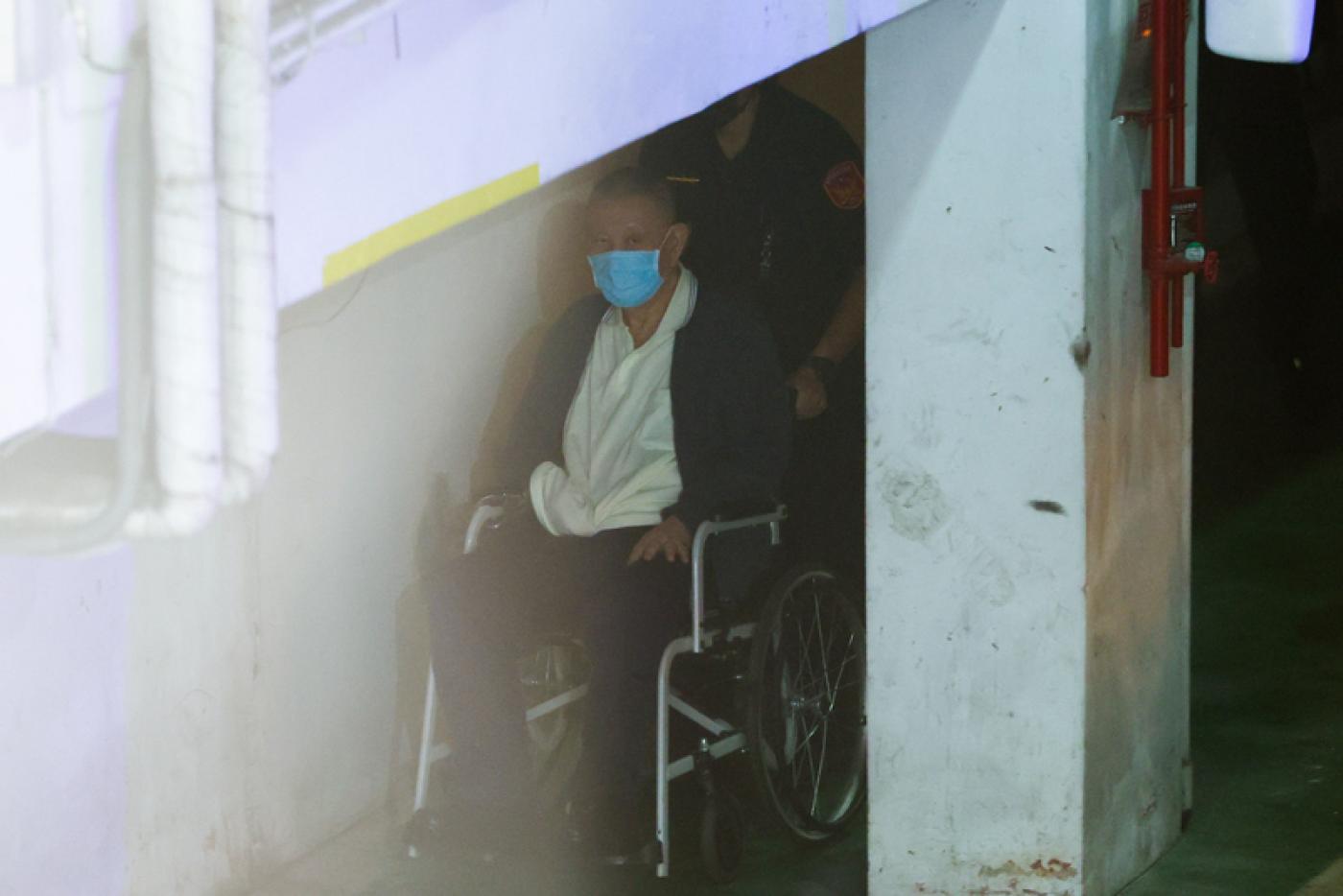 威京集團主席沈慶京（前），8日坐輪椅進入法院。中央社
