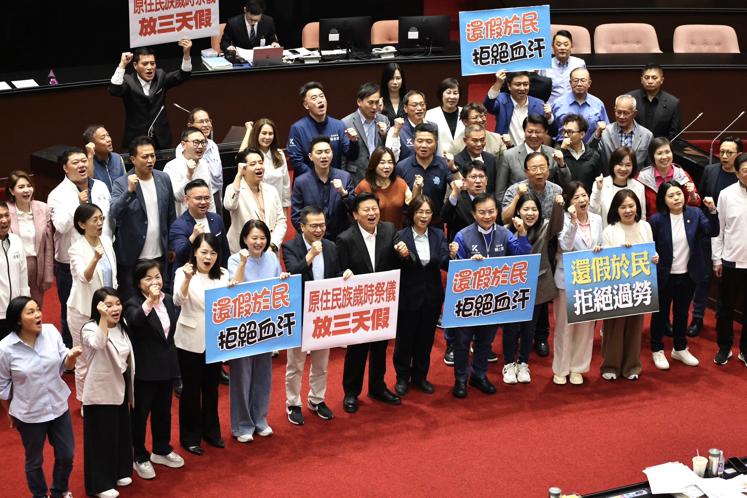 立法院通過「紀念日及節日實施條例」後，國民黨立委舉標語歡呼。林啟弘攝