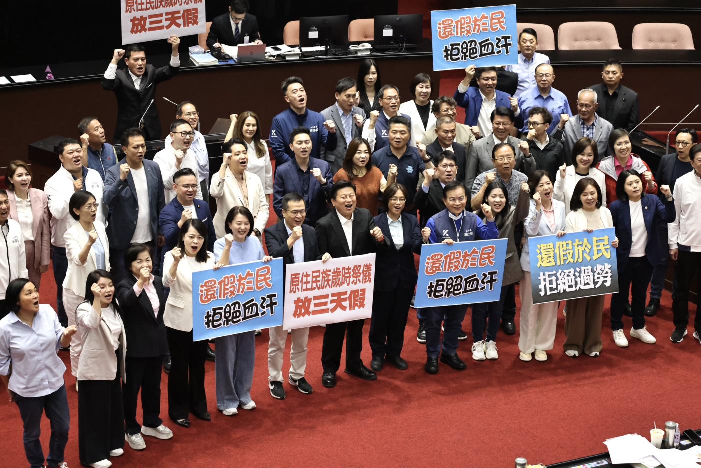 立法院通過「紀念日及節日實施條例」後，國民黨立委舉標語歡呼。林啟弘攝