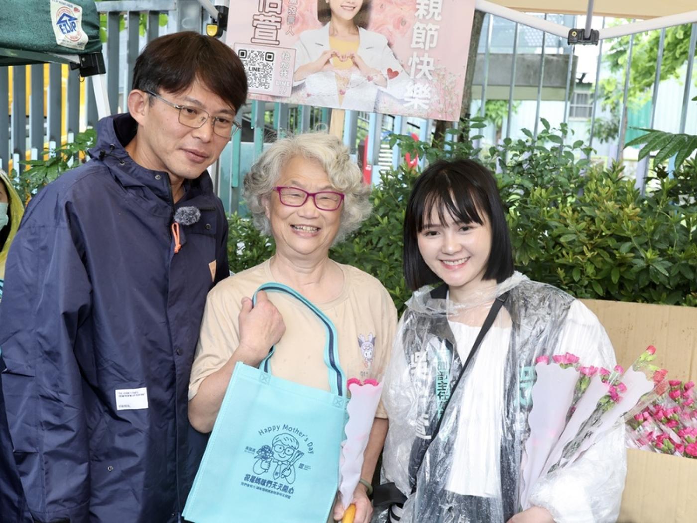 民眾黨主席黃國昌（左）帶著曾在萬華參選市議員的發言人吳怡萱（右）11日母親節到台北市萬華雙和市場發康乃馨，與民眾合影，並且認為應該罷免當地民進黨立委吳沛憶。 中央社