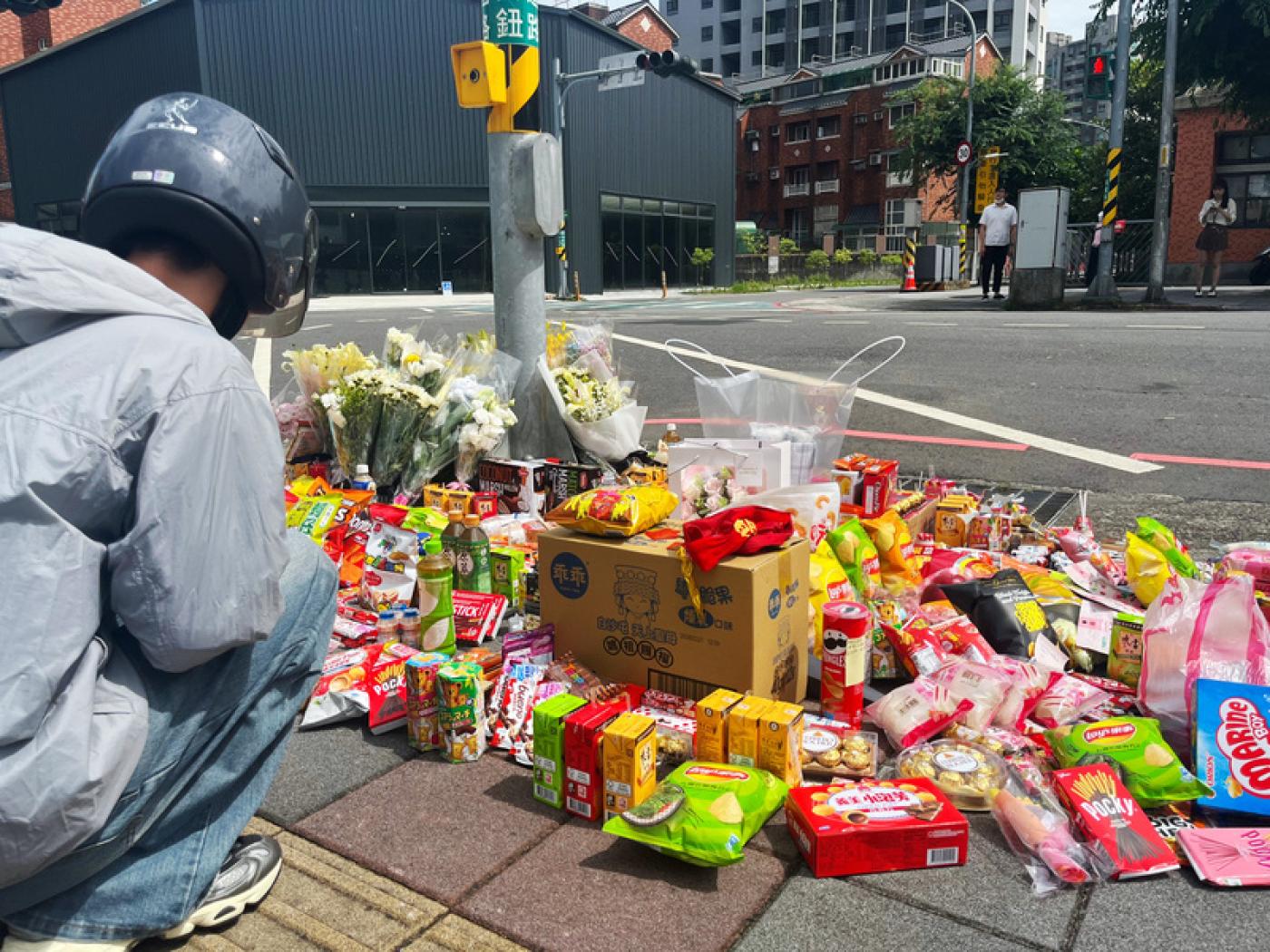 新北市三峽區北大國小外重大車禍，20日上午事故現場擺滿鮮花及零食，向逝者致意，願他們安息。 中央社