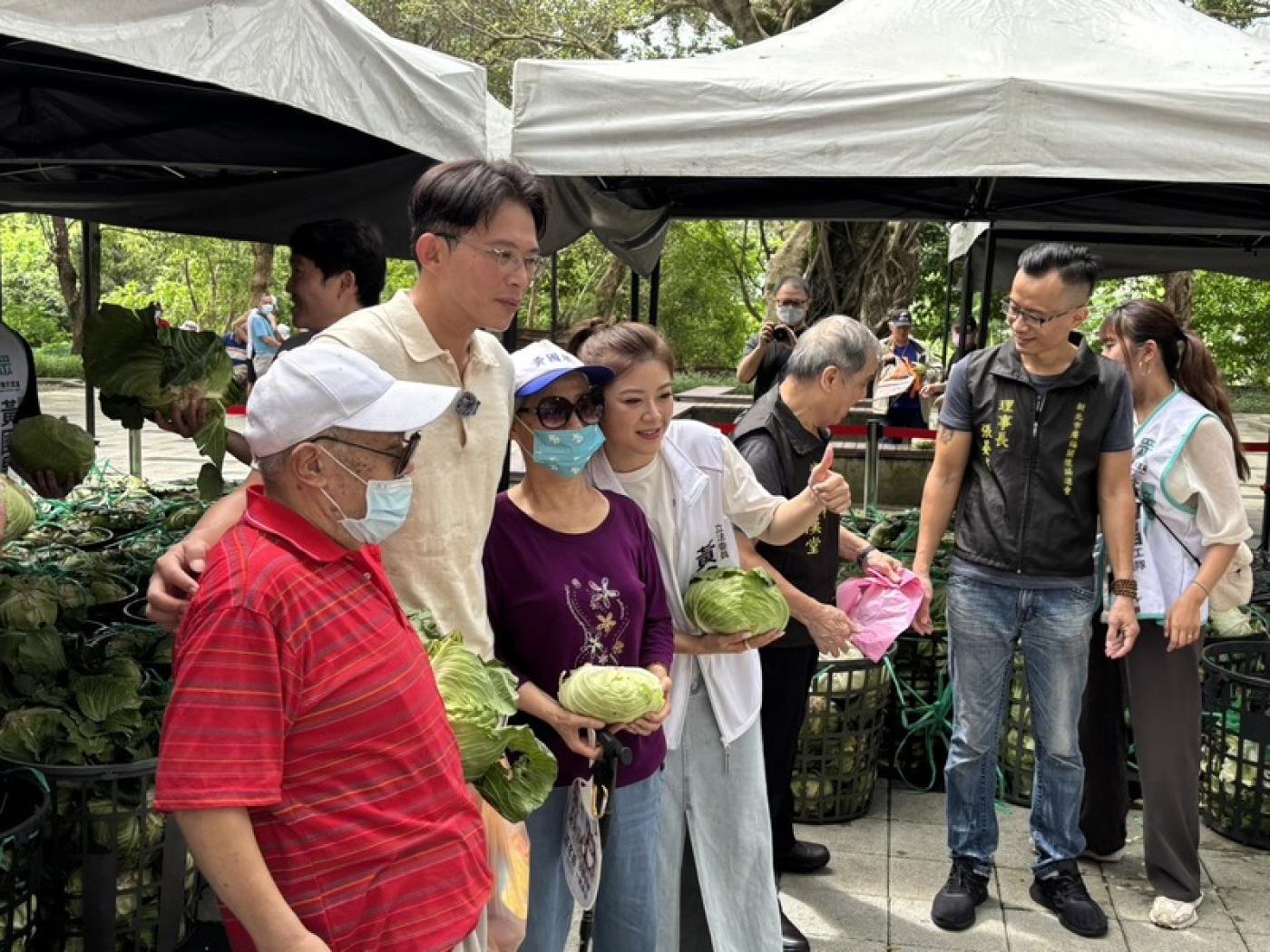 民眾黨主席黃國昌（左2）14日偕新北服務處板橋區主任林子宇（左4）發放高麗菜給在地居民。中央社