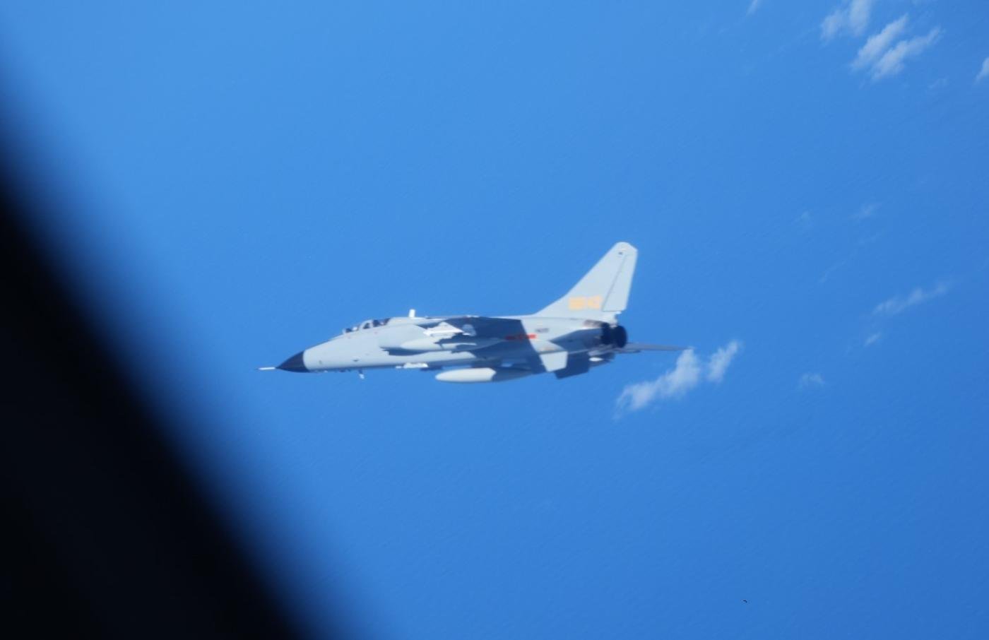 一架中國殲轟-7戰鬥轟炸機在東海公海上空進行監視的航空自衛隊YS-11EB情報收集機附近飛行了約15分鐘，兩機最近水平距離約30米。翻攝日本防衛省
