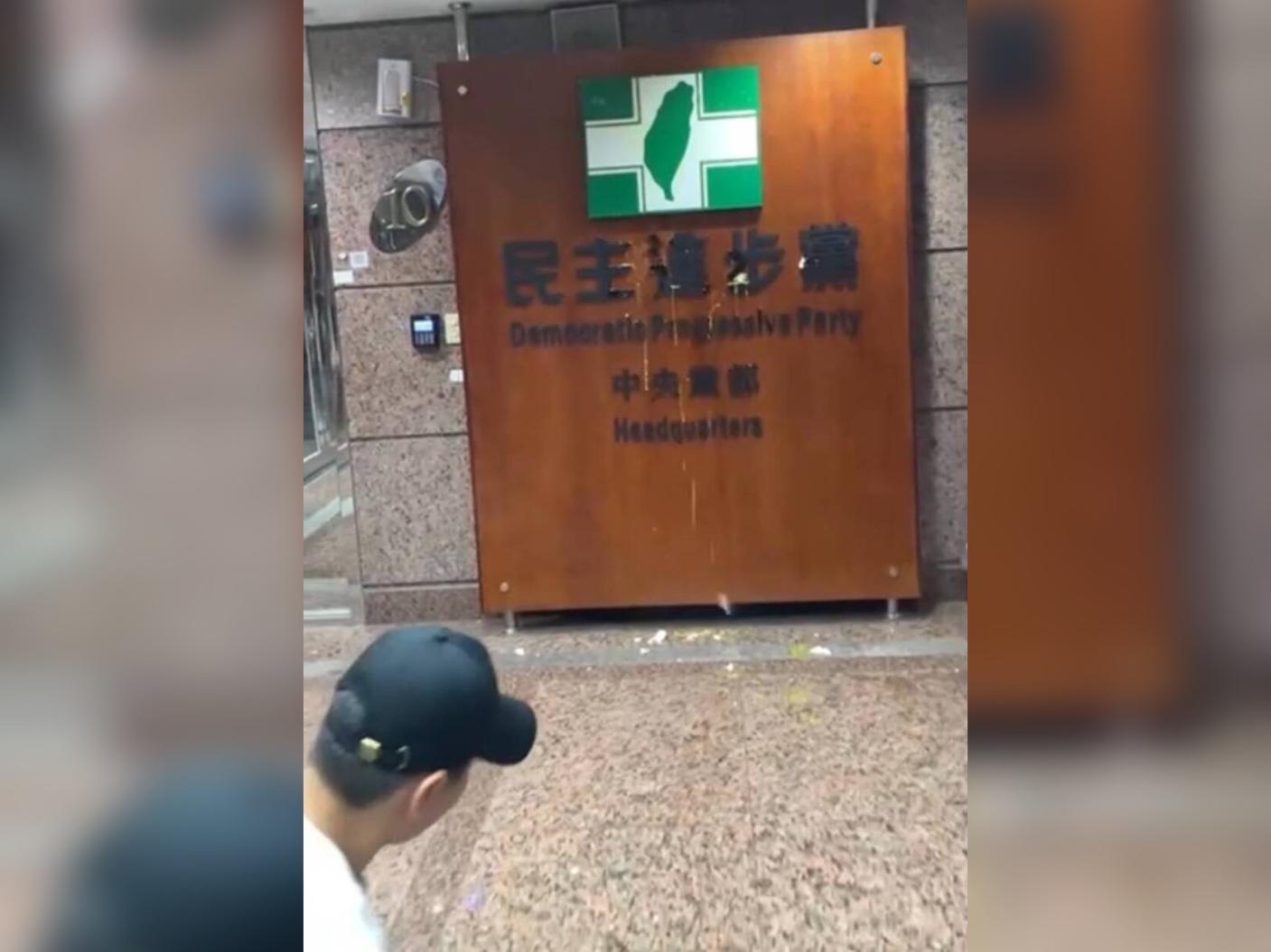 有民眾20日傍晚闖入民進黨中央黨部朝招牌連續丟擲雞蛋。翻攝畫面
