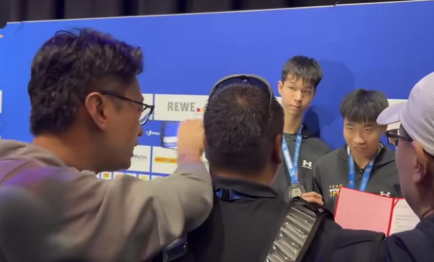 中國男子試圖搶奪得牌選手的總統府賀電，被體育署人員阻擋後，高聲要求選手賀電「合起來」，而且不斷推擠。翻攝鄭世忠臉書