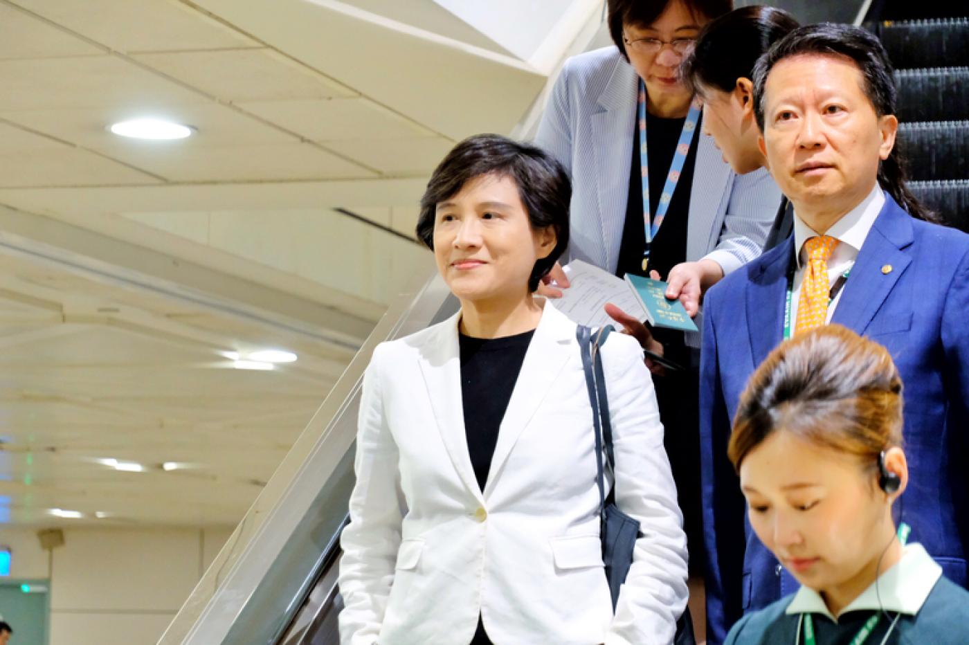 行政院副院長鄭麗君（左1）3日清晨搭機返台，她表示，「談判還要繼續進行，我們會繼續努力，爭取更好的稅率」。 中央社