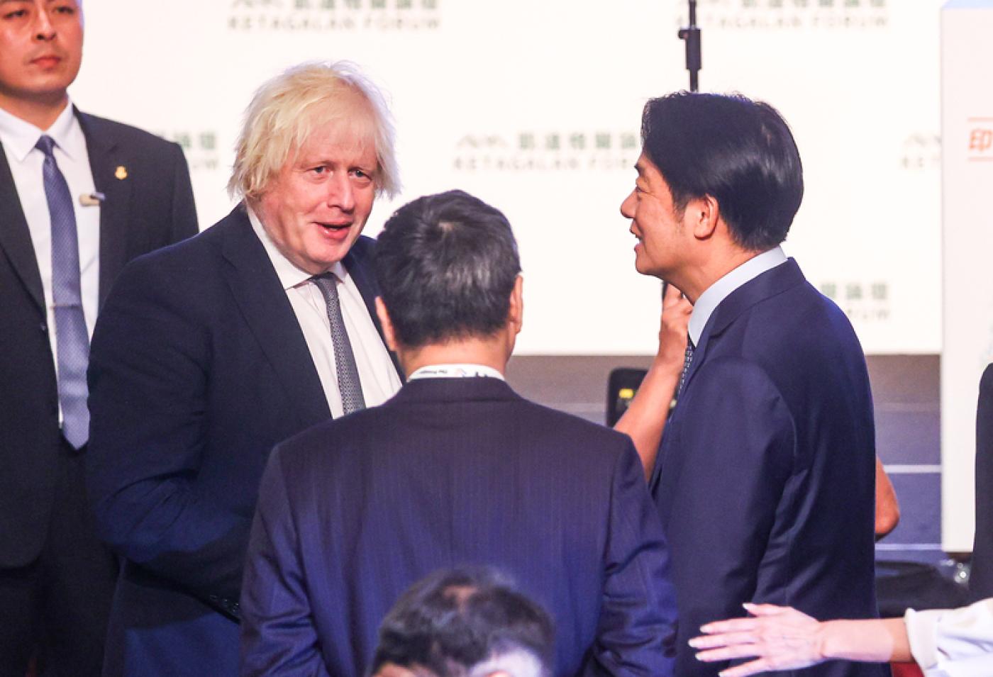 總統賴清德（右）5日上午在台北出席「凱達格蘭論壇：2025印太安全對話」開幕式，與英國前首相強生（Boris Johnson）（前左）在會中握手寒暄。 中央社