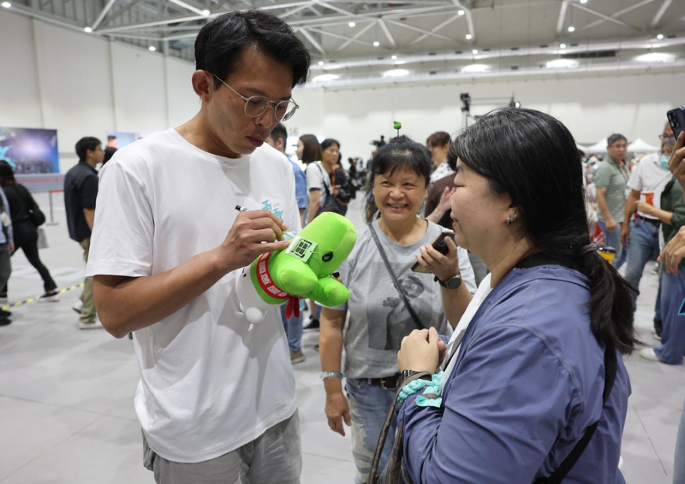 黃國昌（左1）在宣布維持「2年條款」後，接下來他決定要參選新北市長，開始全市走透透。圖為10日黨代表大會中黃替支持者簽名。中央社