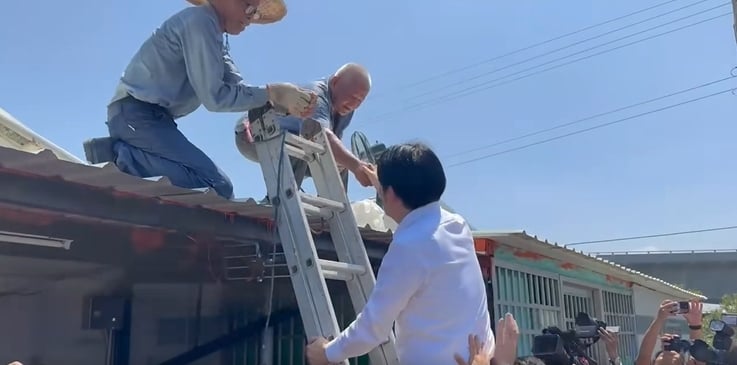 總統賴清德7度視察台南災後復原，爬鋁梯上屋頂送水給工班致意。總統府提供