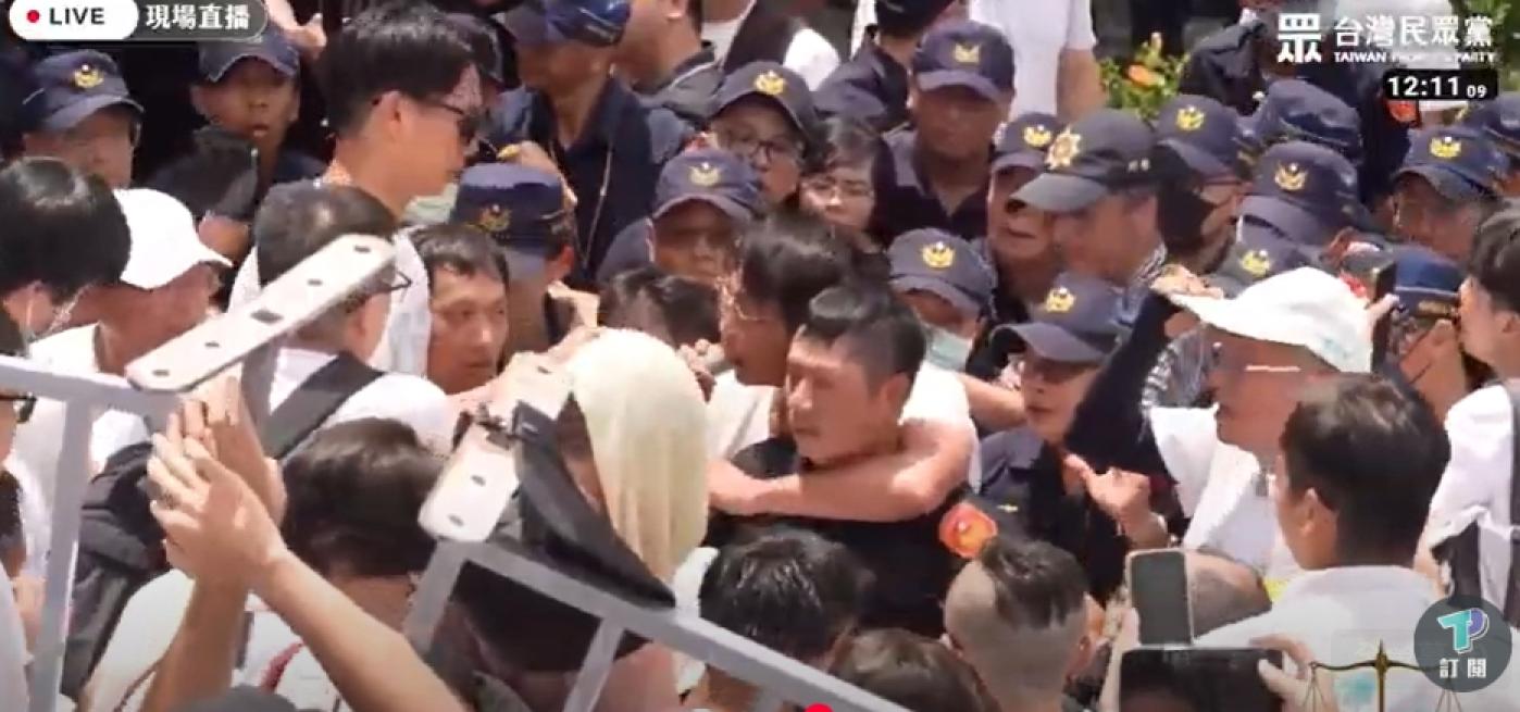 黃國昌翻過柵欄後，被困在員警陣中，用手勒住員警脖子。翻攝民眾之聲