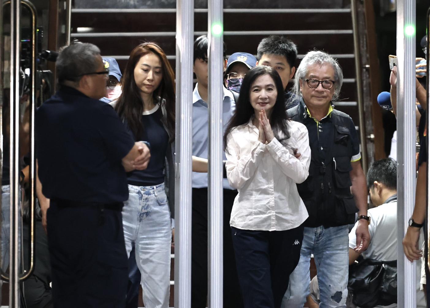 應曉薇晚間在律師及胞兄攙扶下雙手合十步出法院。林啟弘攝