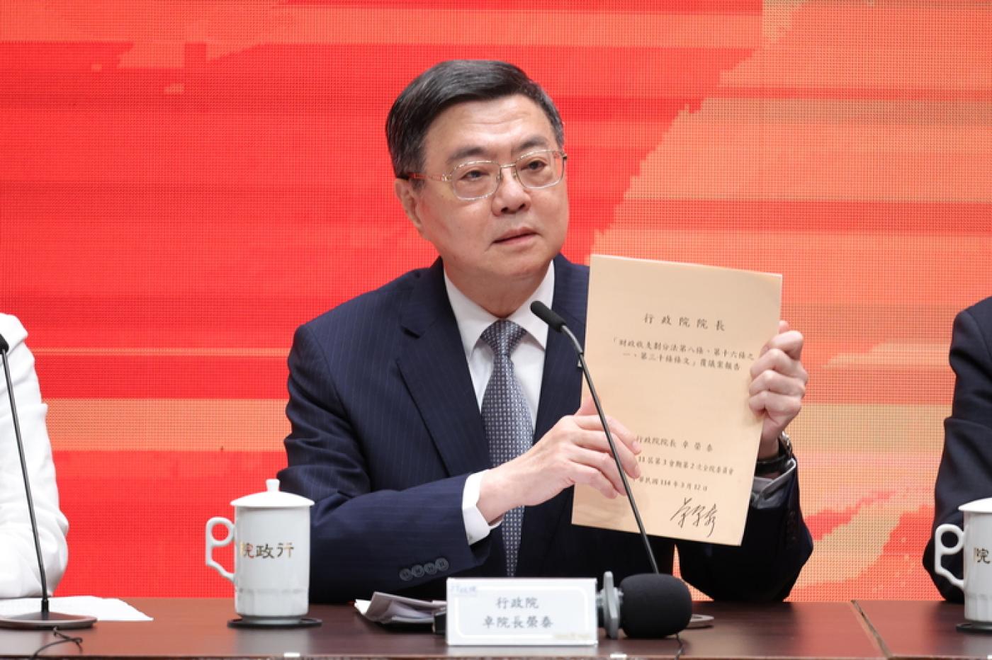 行政院長卓榮泰（圖）記者會中，拿出政院先前針對《財劃法》所提覆議案說明。中央社