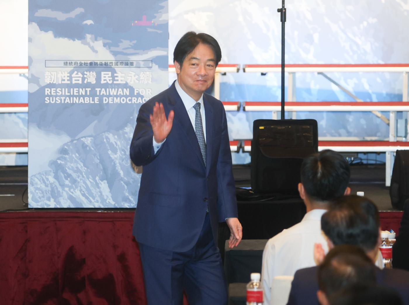總統賴清德（左）20日在台北出席總統府全社會防衛韌性國際論壇開幕式，揮手向與會來賓致意。中央社