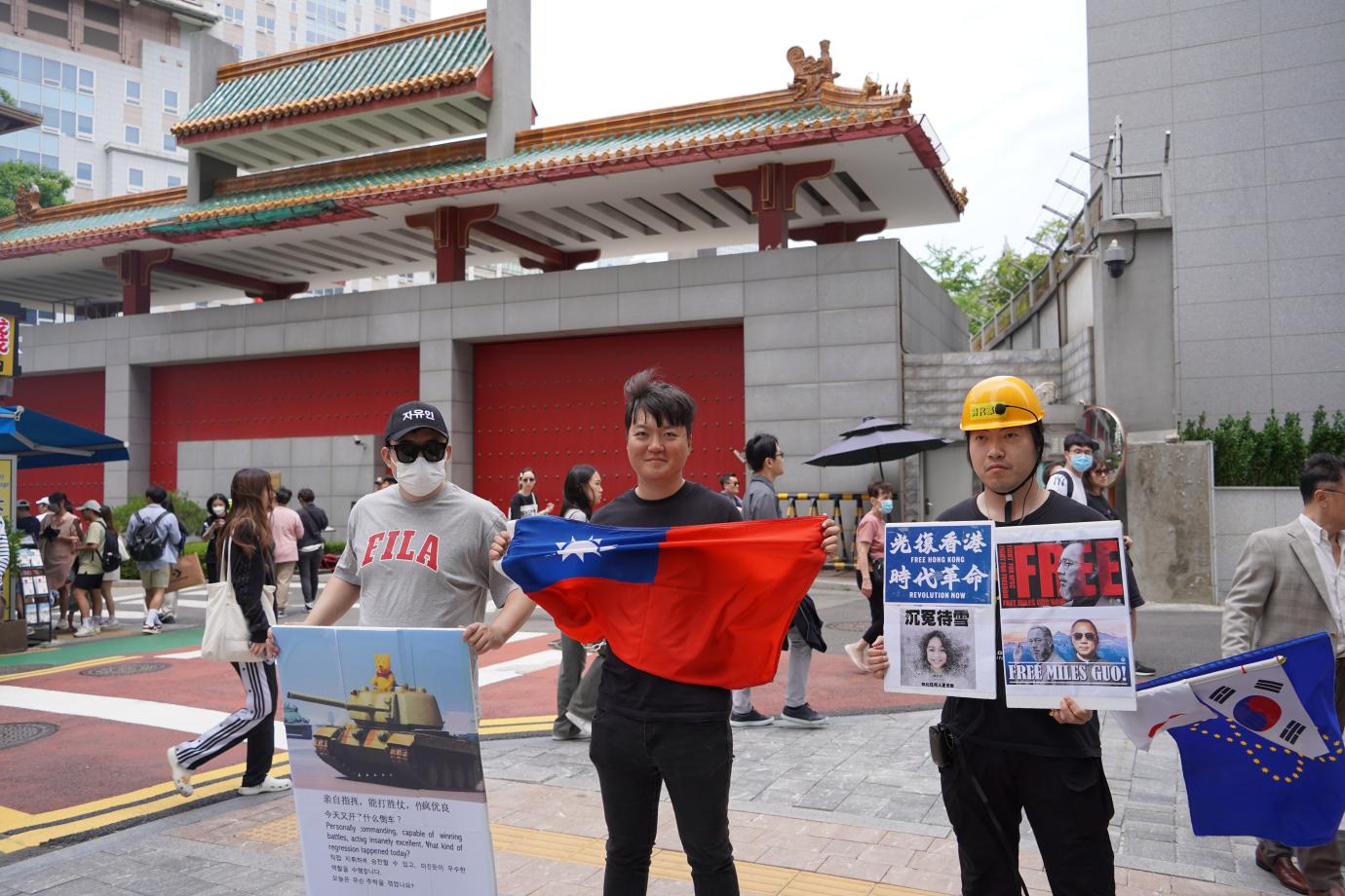 白紙運動的中國學生古金來（左）、韓籍社運人士洪在沅（中）和阿燦陽（右）在中國駐韓大使館前示威。吳珮如攝