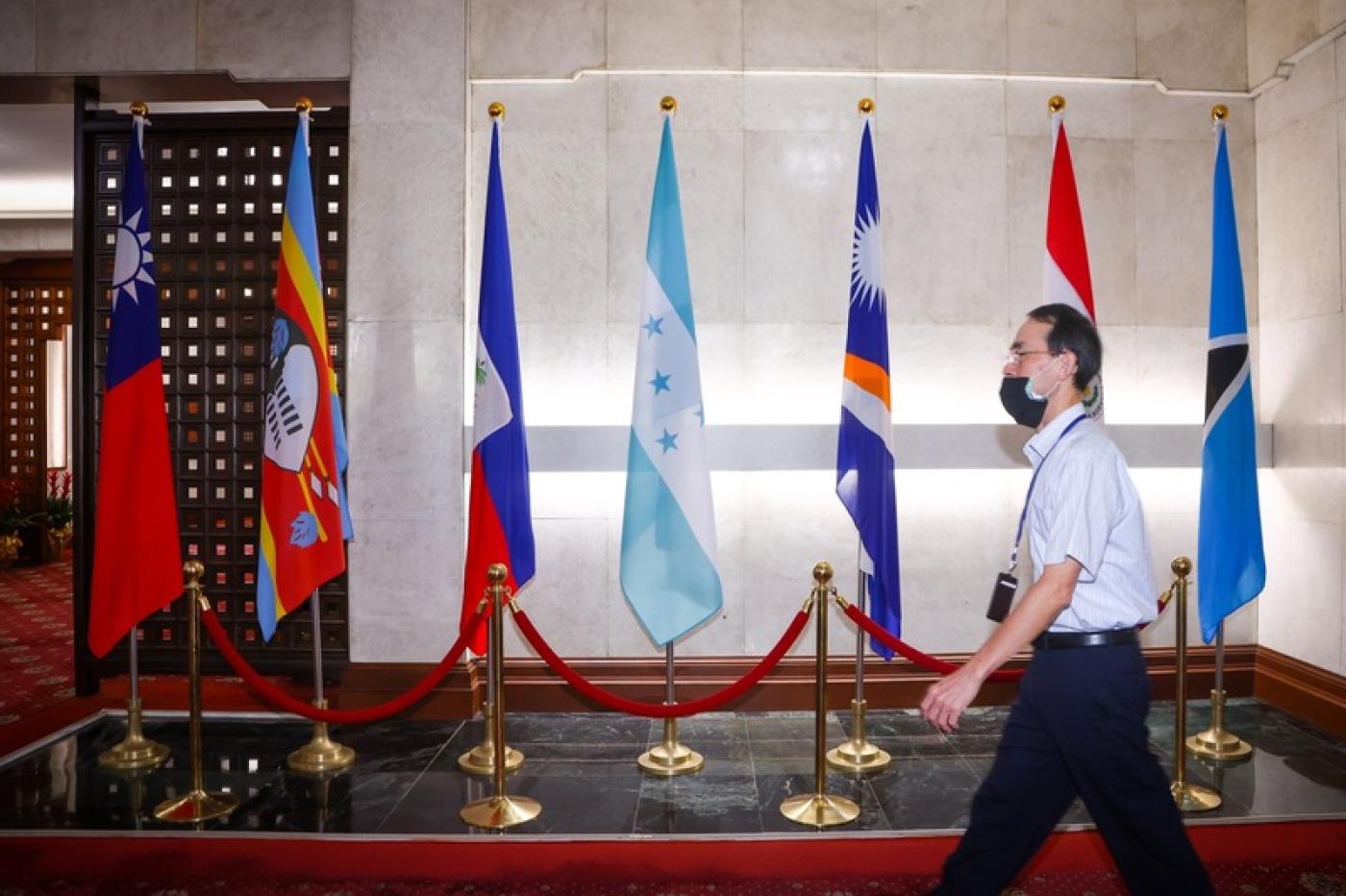  宏都拉斯總統卡斯楚14日宣布將與中國發展官方關係。圖為外交部員工經過一樓大廳宏都拉斯國旗（左4）。中央社
