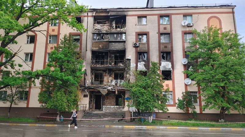 烏克蘭首都基輔市附近的布查鎮，一名路人走過3月間被俄軍砲轟的公寓。